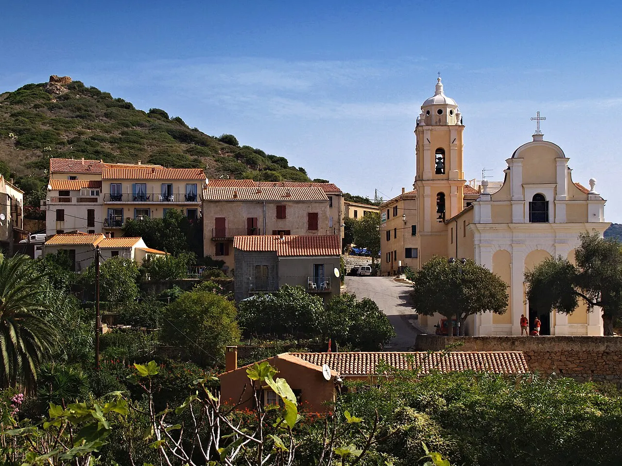 Cargèse (Corse) - Le quartier au sud-ouest du village avec l'église Latine. Au sommet de la colline, un moulin ruiné