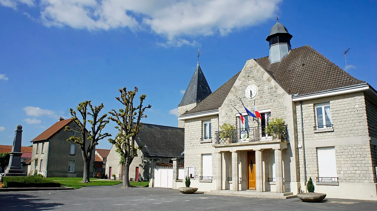 La place du village avec la Mairie, l'église et le monument aux morts de Caurel.