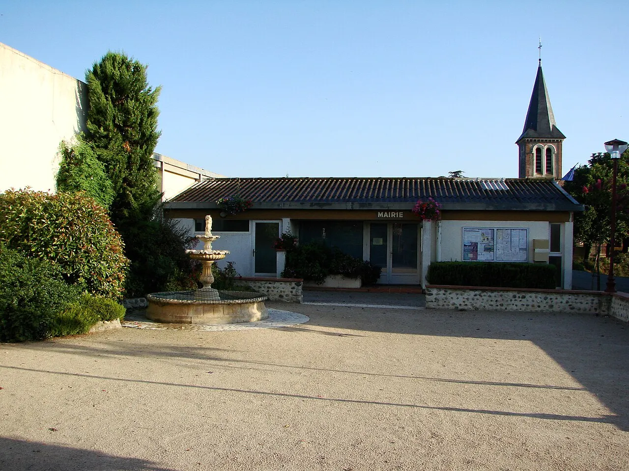Vue du village de Dours dans les Hautes-Pyrénées (France) : mairie, place du village et église en fond