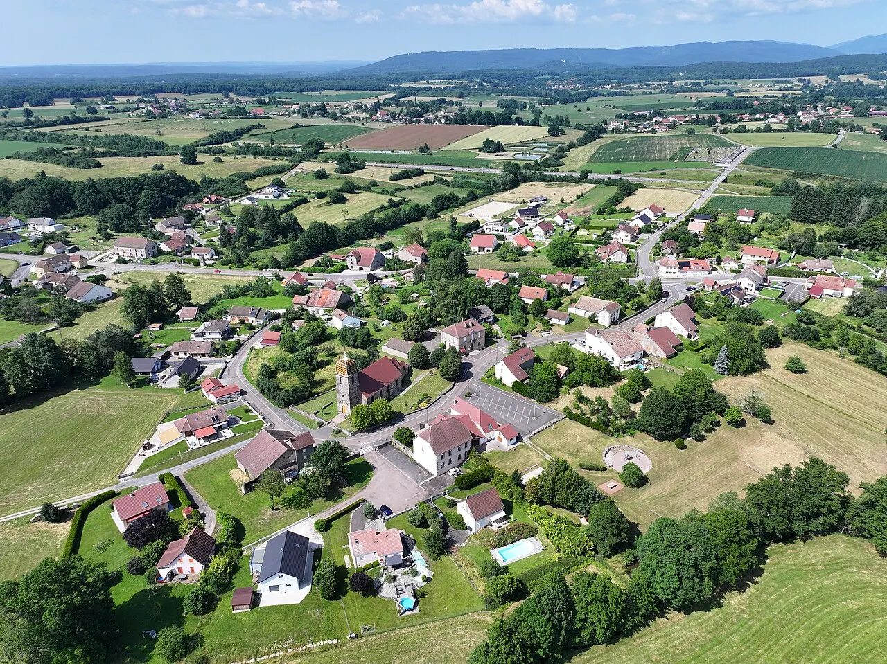 Vue aérienne de Lyoffans avec les Vosges en arrière-plan.