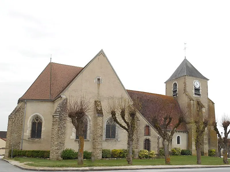 Eglise romane en pierres couverte en tuiles, clocher porche carré surmonté d'un pavillon en ardoise